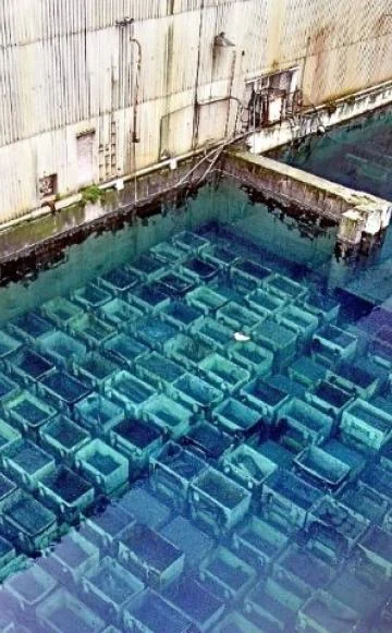 A storage pond with rows of submerged containers under blue water