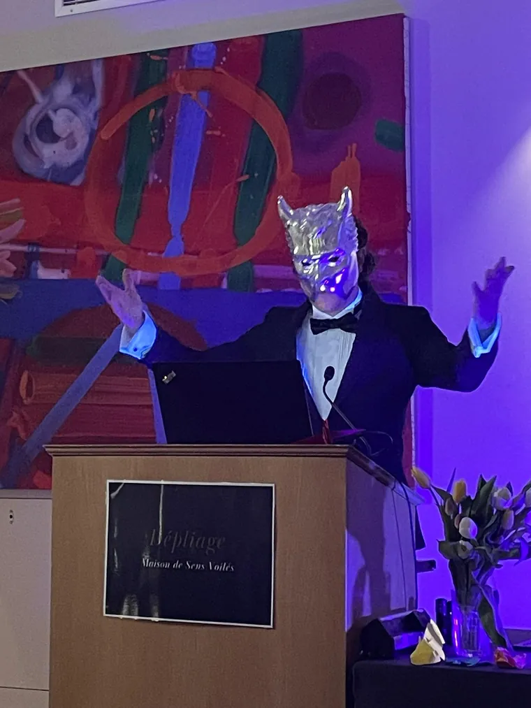The masked auctioneer at The Unfolding