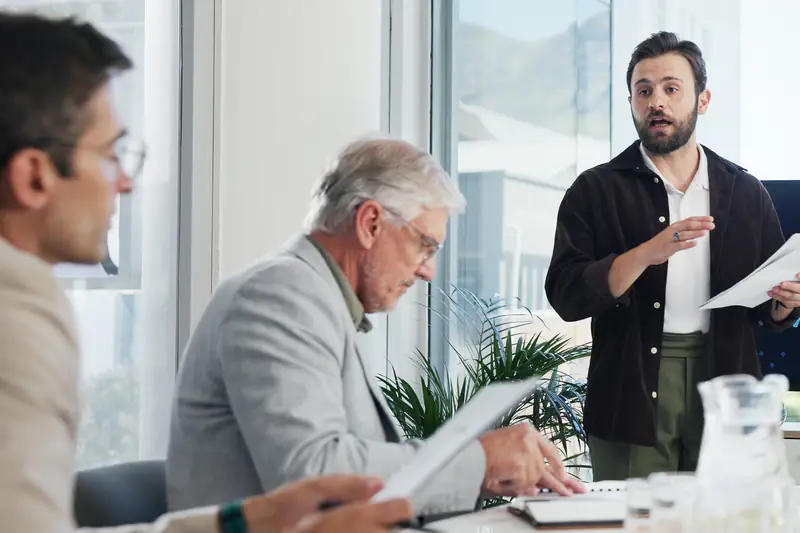 Colleagues listening to a presenter in a meeting room