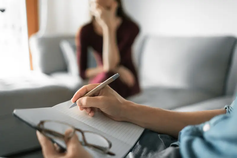 A coach taking notes during a conversation about stress