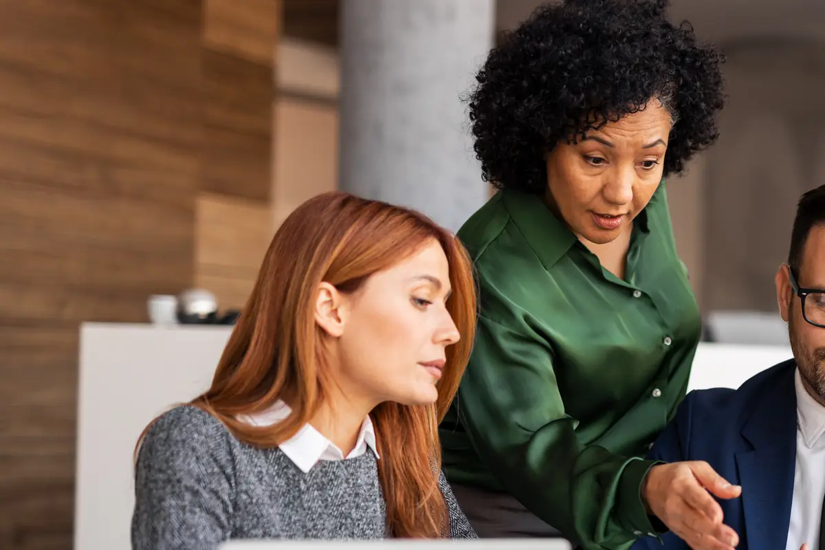 Colleagues gathered around a laptop