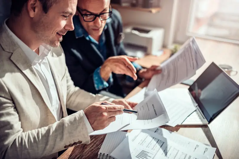 Two colleagues reviewing documents together before anything is quoted
