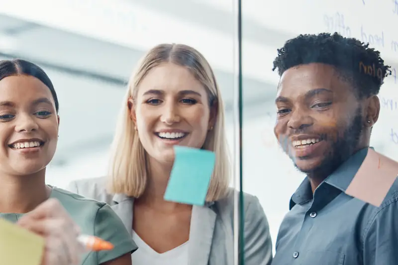 Smiling colleagues brainstorming with sticky notes
