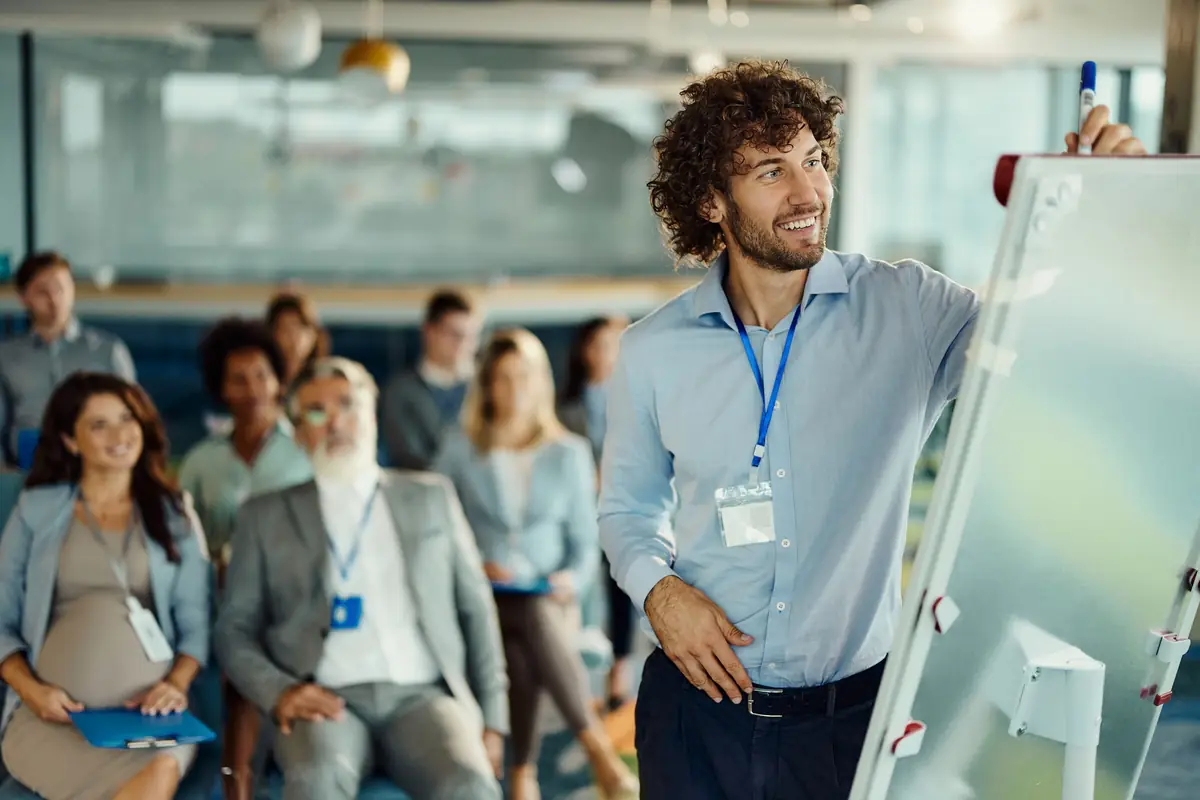 A facilitator at a whiteboard in front of a large audience