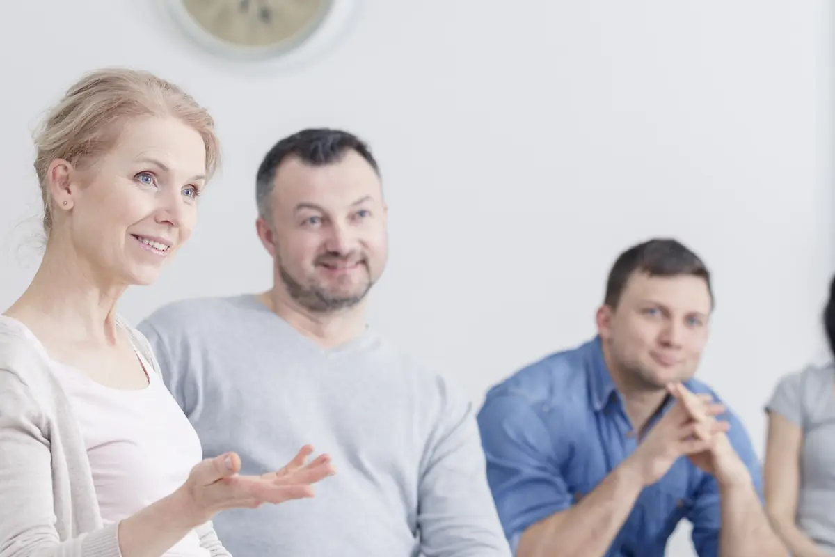 A group in a circle, one woman speaking