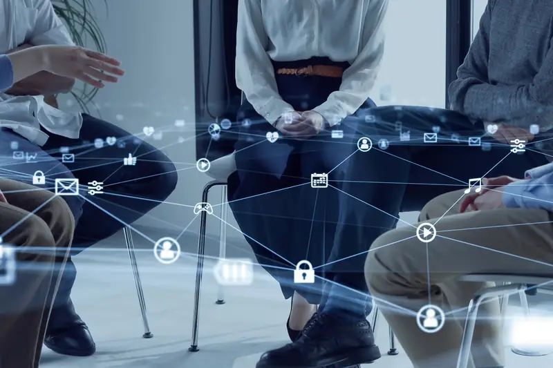 A group seated in a circle with a digital network overlay