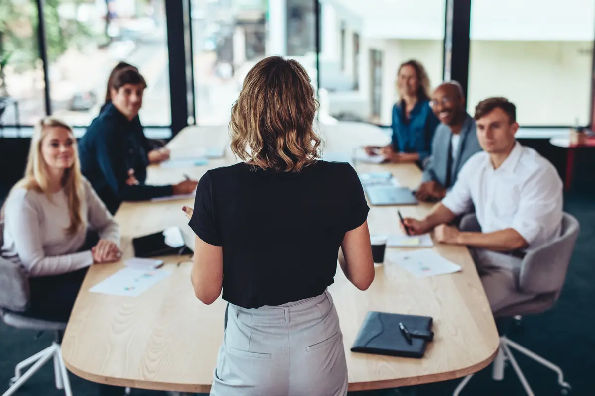 A team leader presenting to colleagues around a meeting table