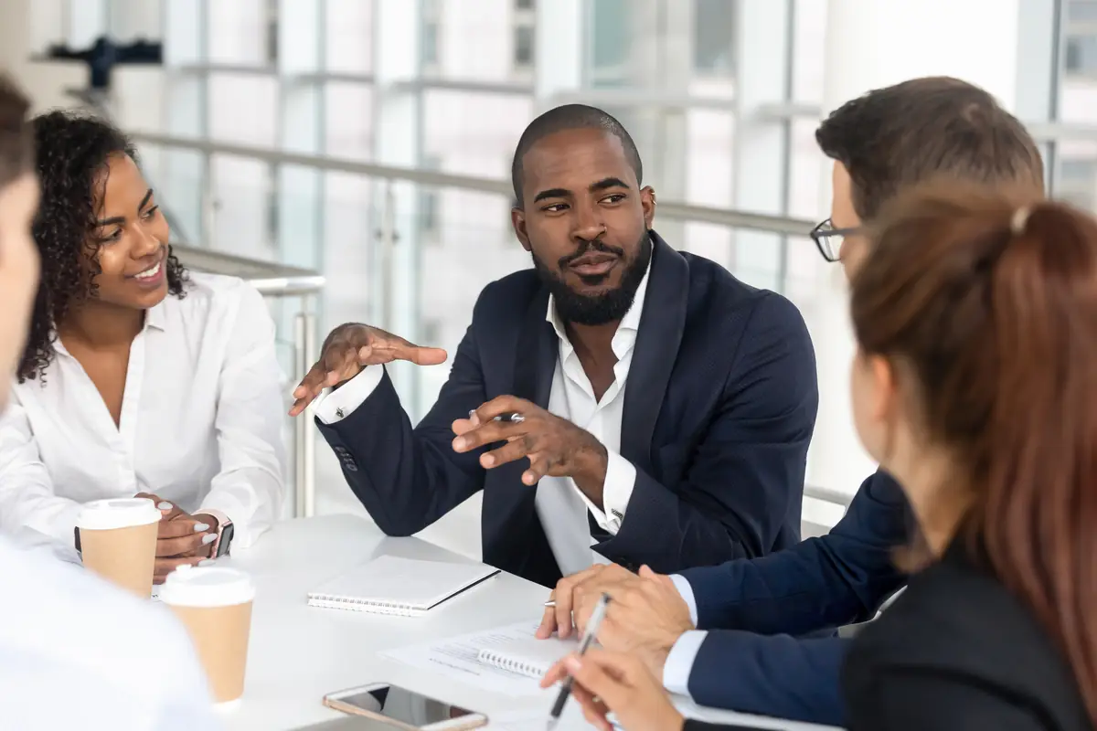 A manager leading a discussion with his team around a table