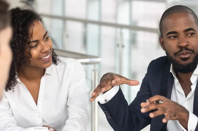 A woman and a man in conversation at a meeting table