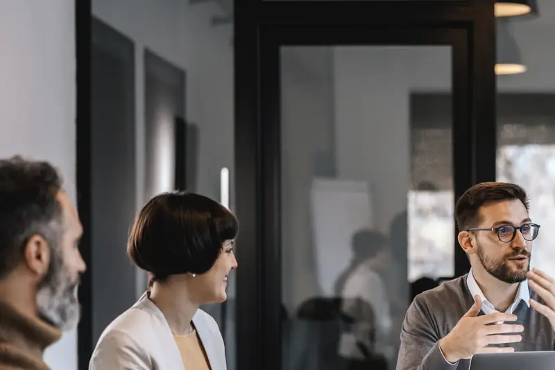 Colleagues in a meeting in a dark-panelled office