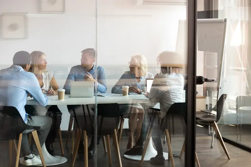 A team meeting seen through a glass wall