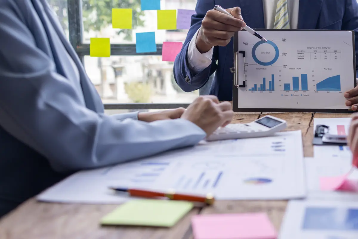 Charts and sticky notes spread across a planning table, the trace of a month that produced too much