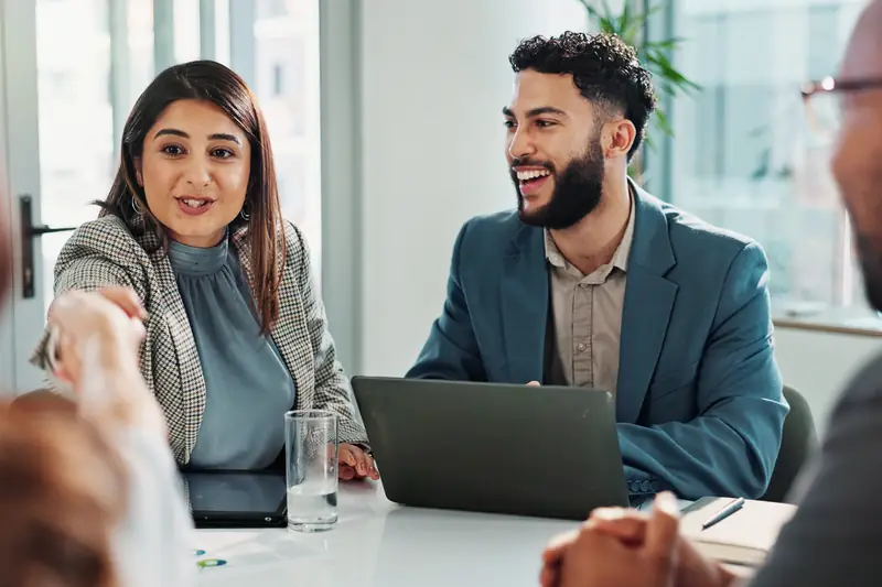 Two colleagues in a positive conversation at a meeting table