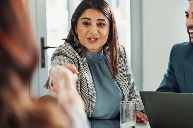 A woman making a point at a meeting table