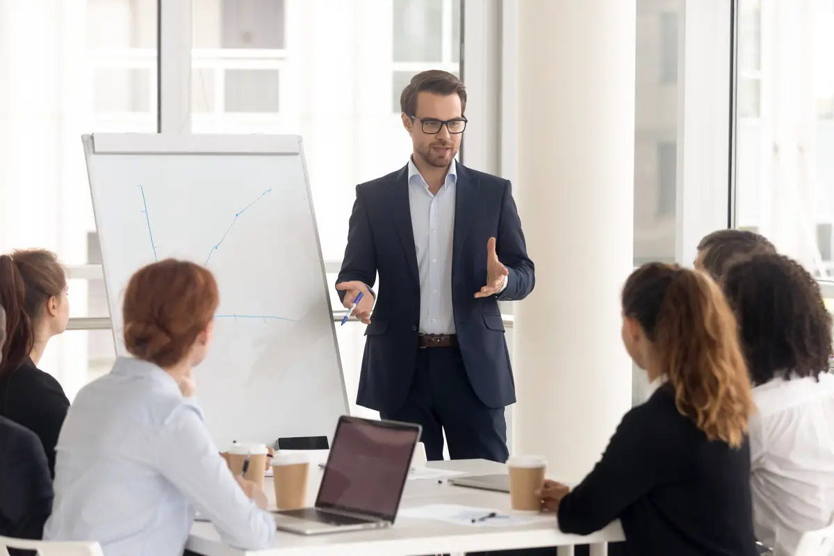 A presenter at a flipchart in front of seated colleagues