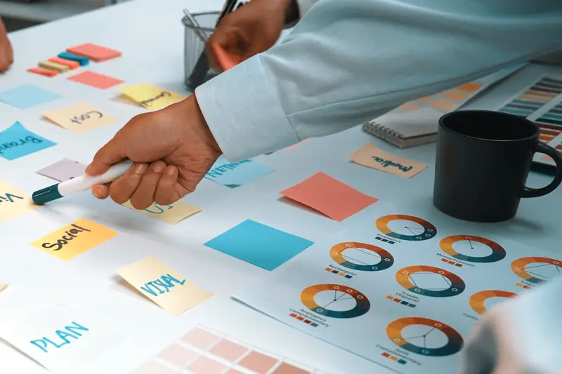 Hands placing sticky notes on a planning sheet