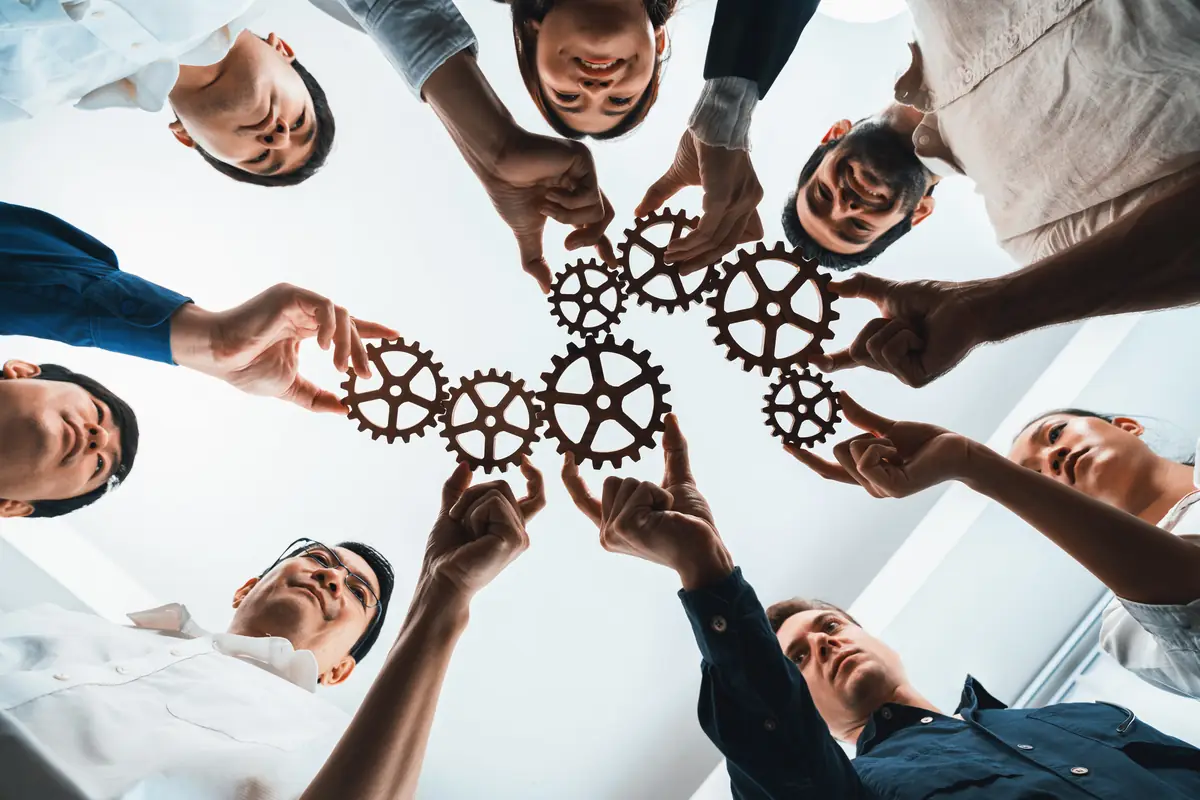 Team members fitting gears together