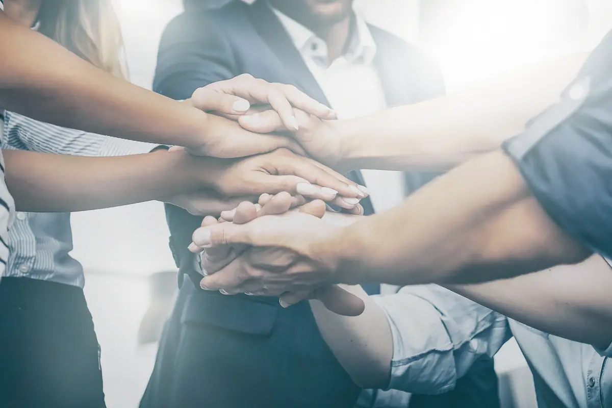 Team members stacking their hands together