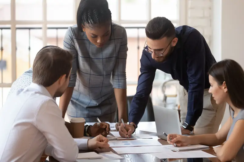 A team leaning over a table to plan together