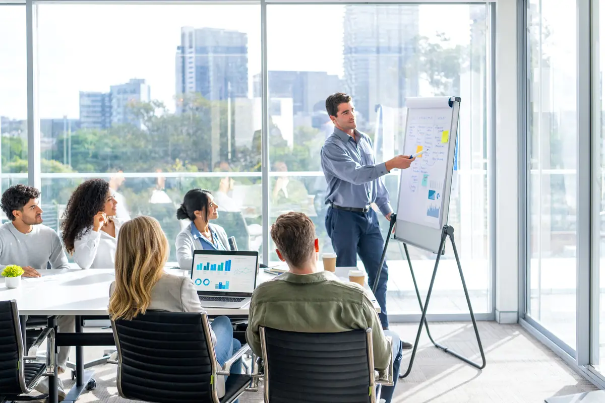 A trainer at a flipchart with a team in a city office