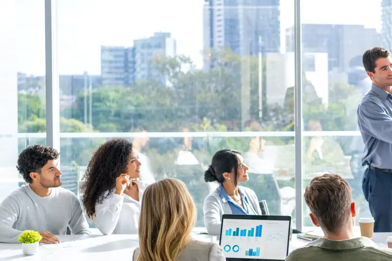 A team in a bright city office watching a presentation