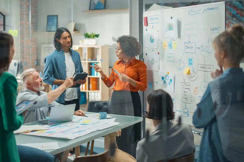A facilitator at a whiteboard running a team workshop