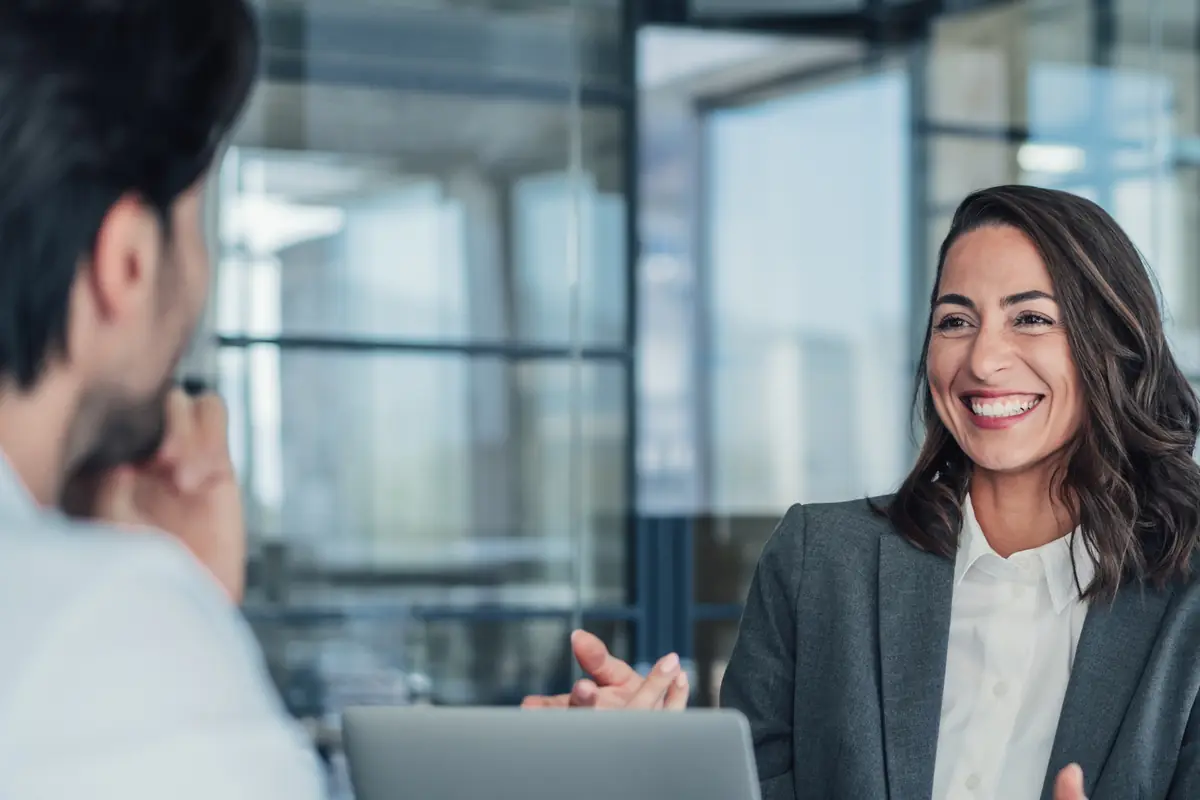 A woman smiling as she leads a meeting