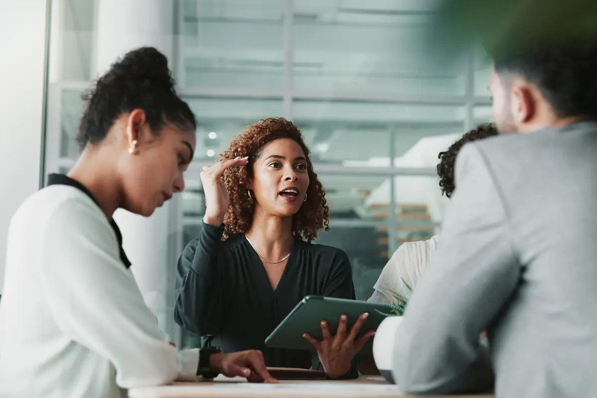 A woman sharing ideas with colleagues around a table