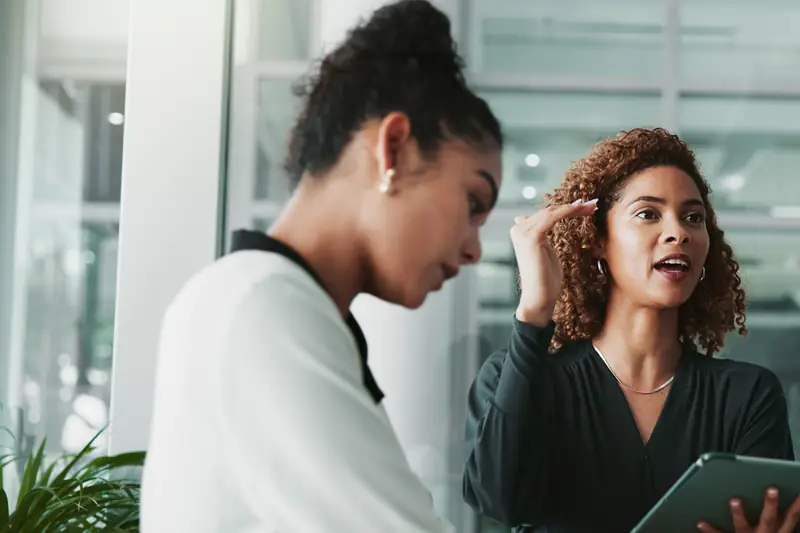 Two women discussing ideas at a meeting table