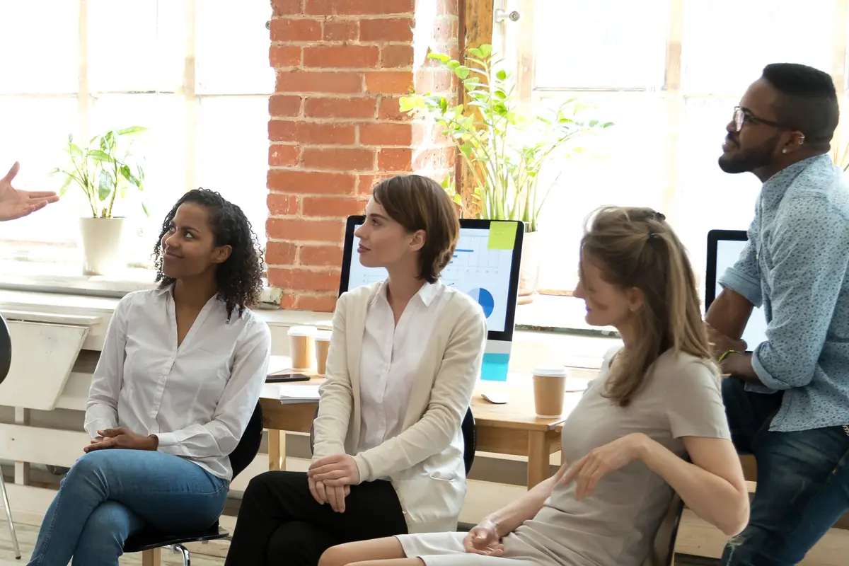 Workshop participants seated in a bright room, listening