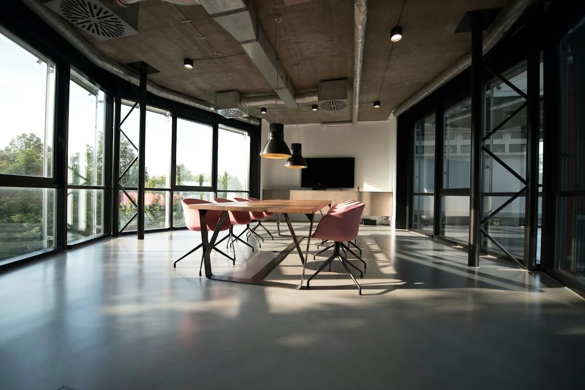 A quiet open-plan office at the end of a working day, with empty chairs and a half-finished coffee on a desk