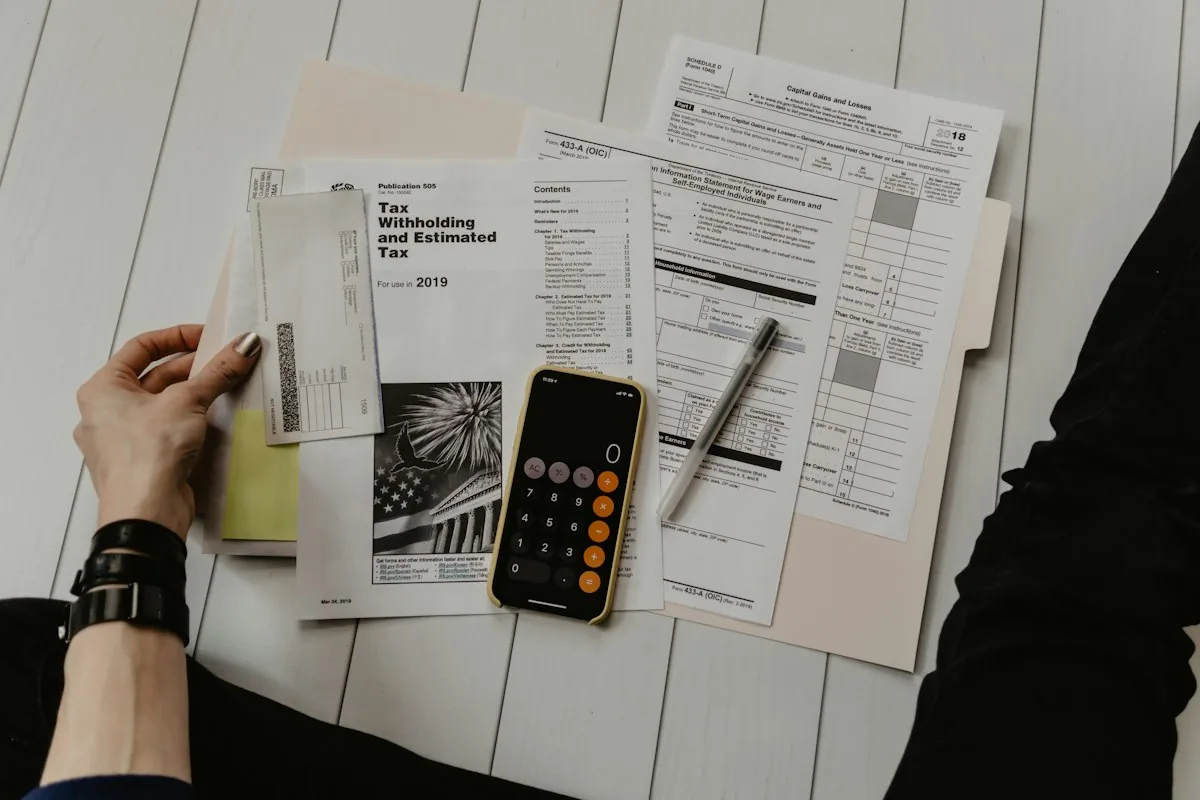 A close-up of hands working with a calculator and notebook in a quiet office